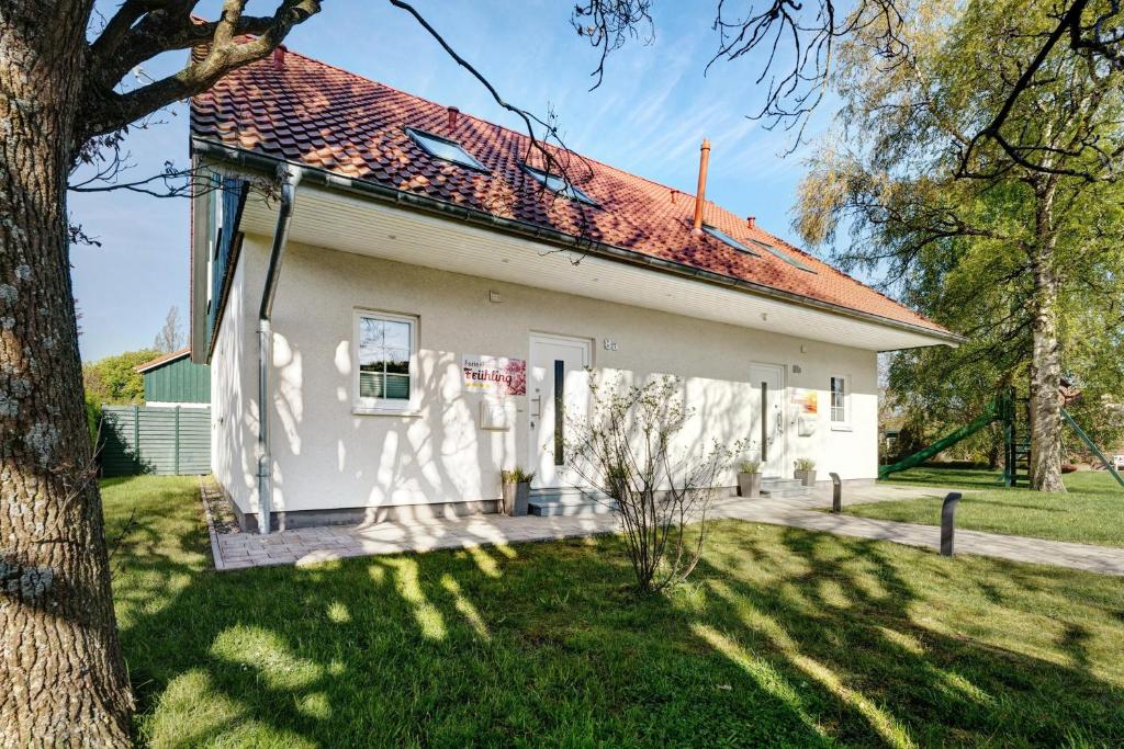 a white house with a red roof at Feriendoppelhaus Frühling in Stakendorf