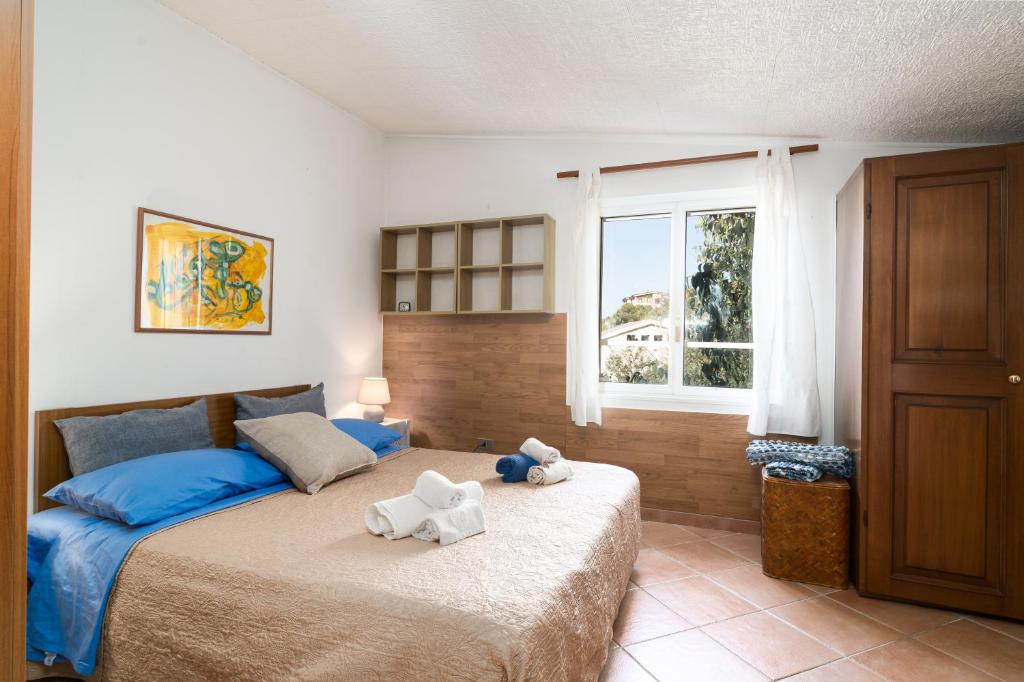 a bedroom with a bed with two stuffed animals on it at Casa Su Craminu in Dorgali