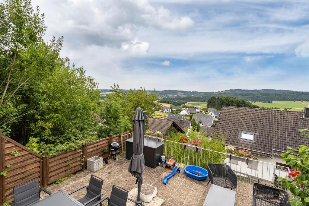 a patio with chairs and an umbrella on a balcony at Perle am Pön in Medebach