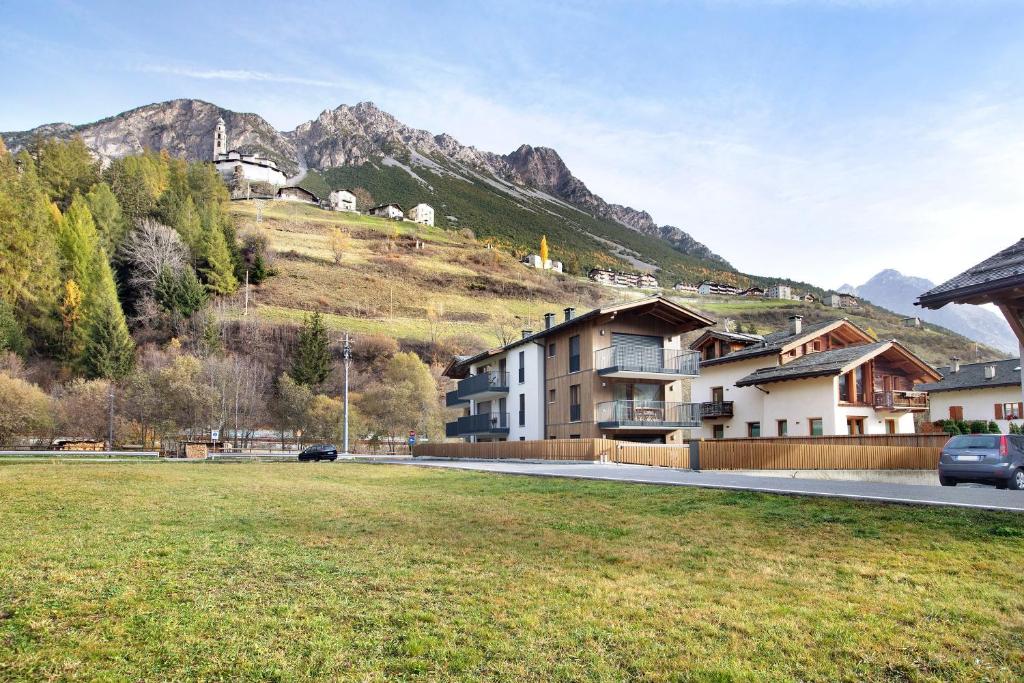 a building on the side of a hill with houses at Violet a due passi da Bormio in Valdidentro