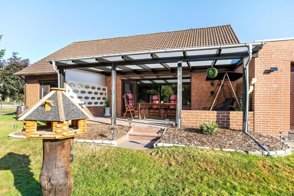 a house with awning and a play structure in the yard at Dörpshus in Rehm-Flehde-Bargen