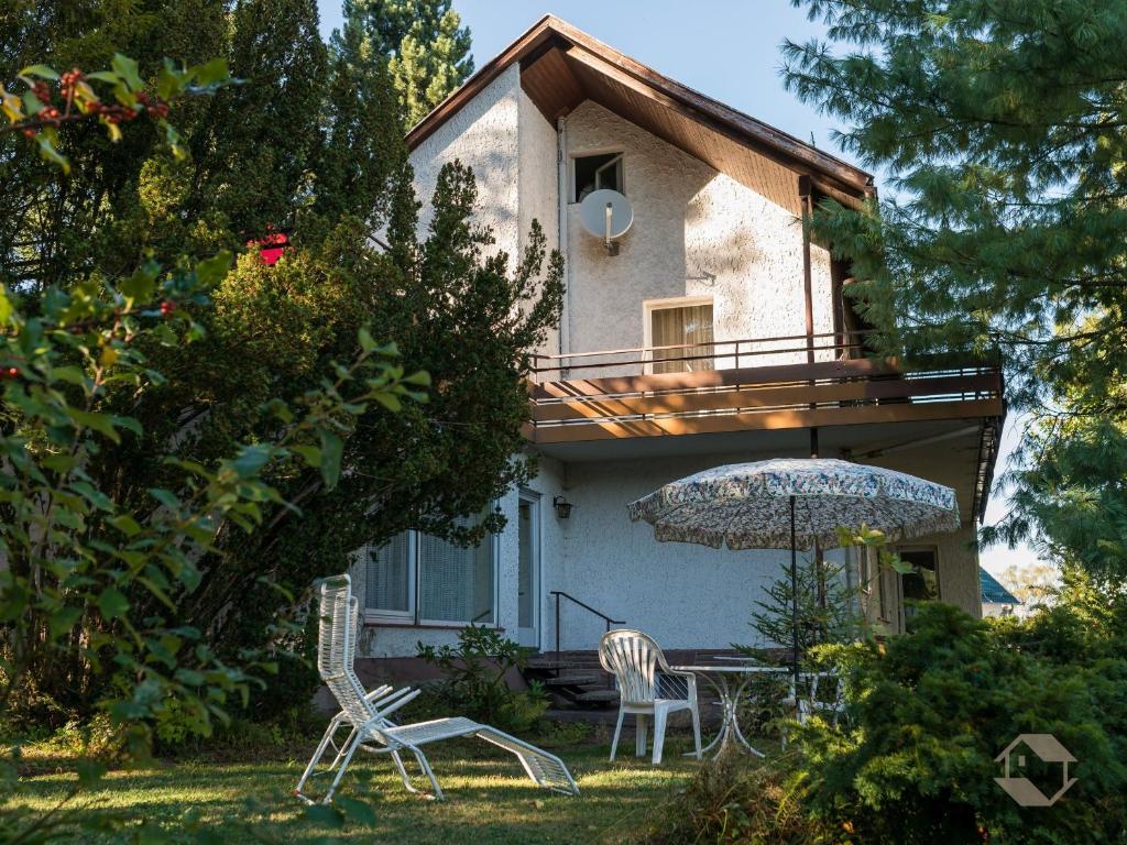 a house with a table and an umbrella in the yard at Gästehaus Hirzel in Bad Wildbad