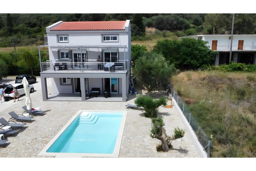 a house with a swimming pool in front of it at Euphoria Apartments in Lixouri