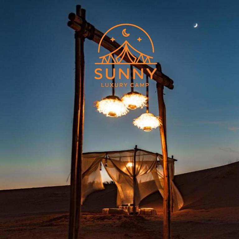 a sign for a suninyiny camp in the desert at Sunny Luxury Camp in Merzouga