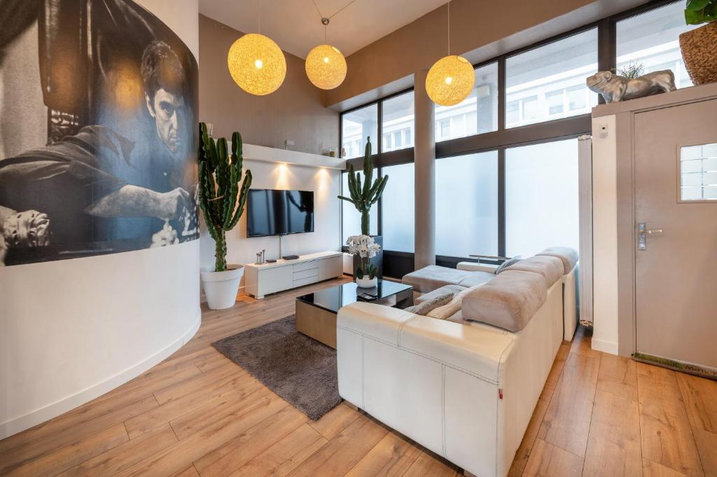 a living room with a couch and a tv at Beau Loft Lorient - centre ville in Lorient