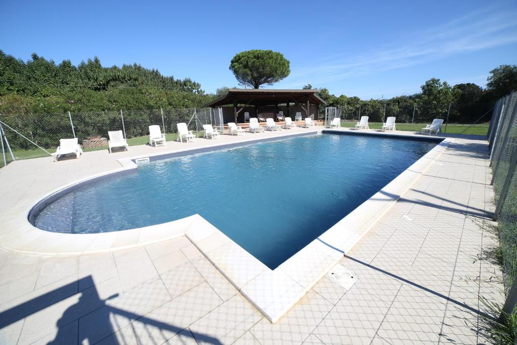 a swimming pool with chairs and a pavilion at Il Vignone - Castagneto Carducci in Castagneto Carducci