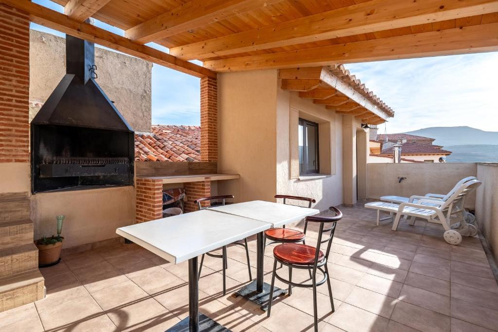 a patio with a table and a fireplace at Sierra De Majalinos in Ejulve