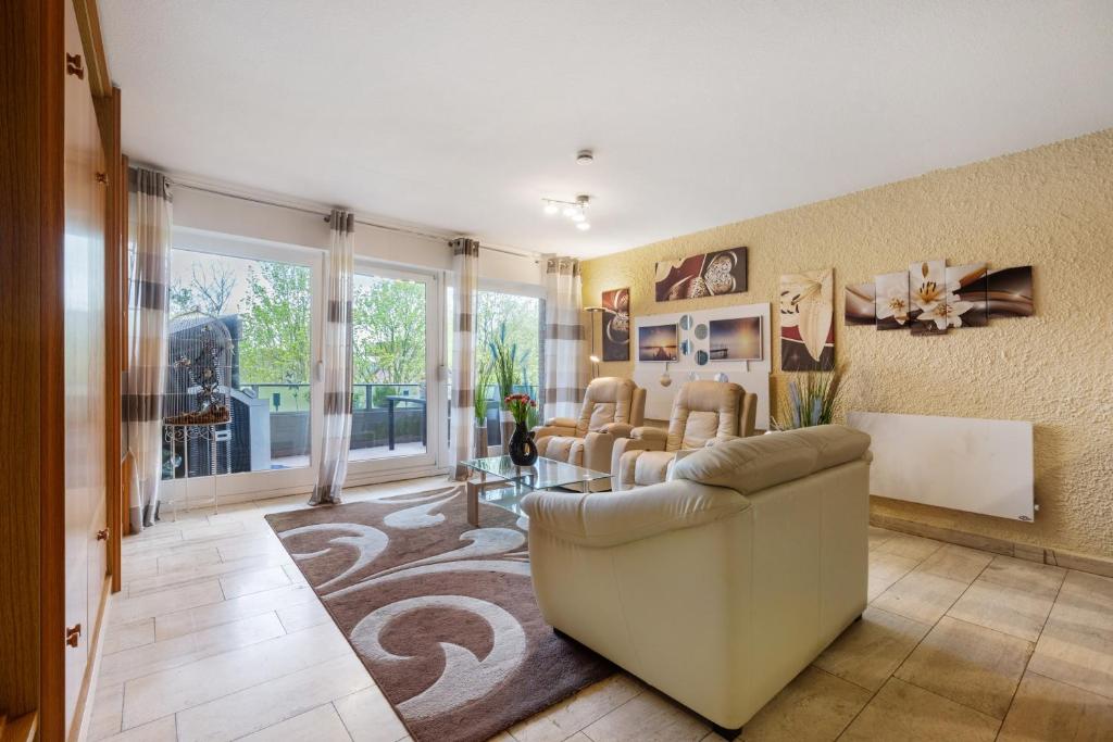a living room with a couch and chairs in it at Apartment Seeadler in Butjadingen