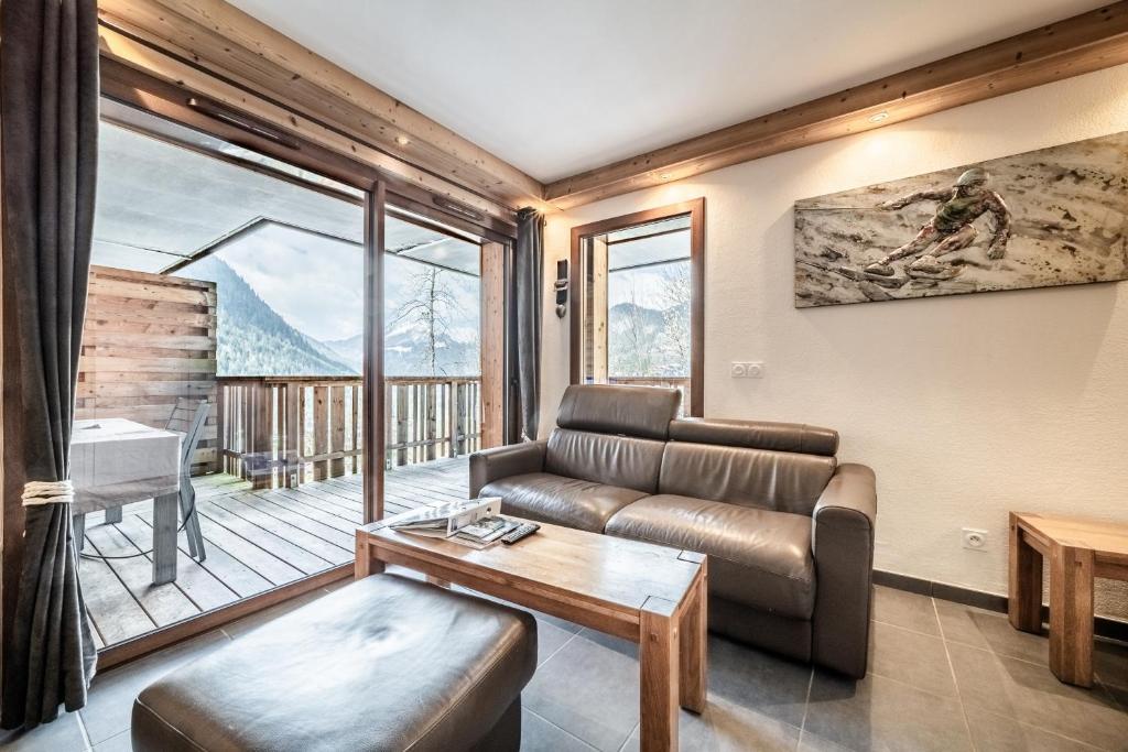 a living room with a couch and a table at Les loges blanches204 centre chatel in Châtel