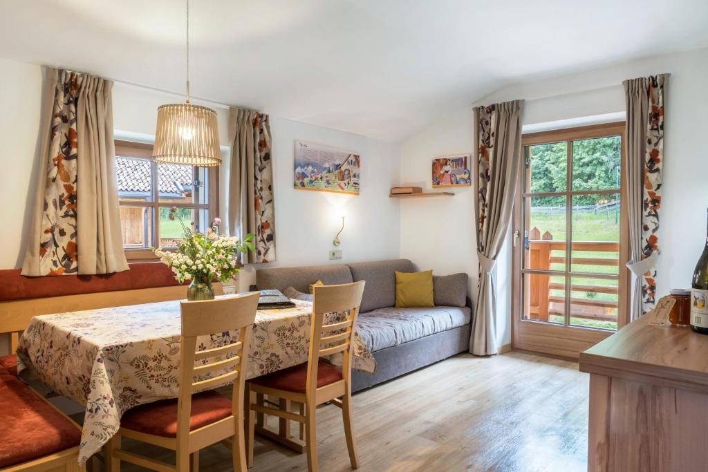 a living room with a table and a couch at Schneewittchen Schlosshof in Völs am Schlern
