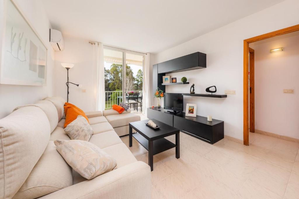 a living room with a white couch and a table at Angy Apartment in Alcudia