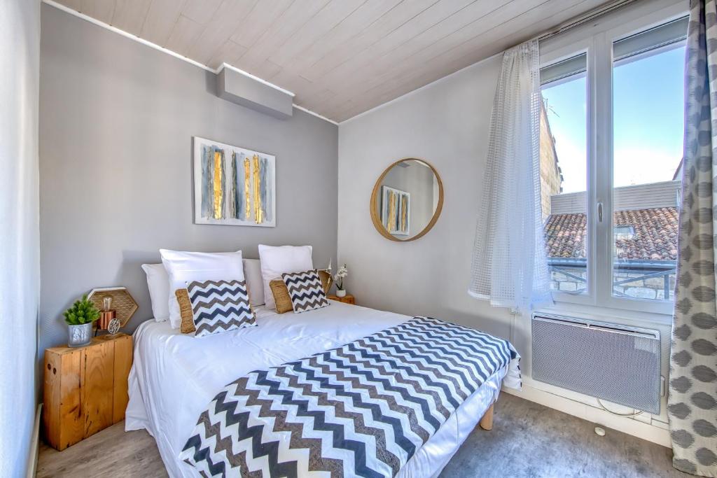 a bedroom with a bed and a large window at Sur La Route Des Vins - Libourne in Libourne