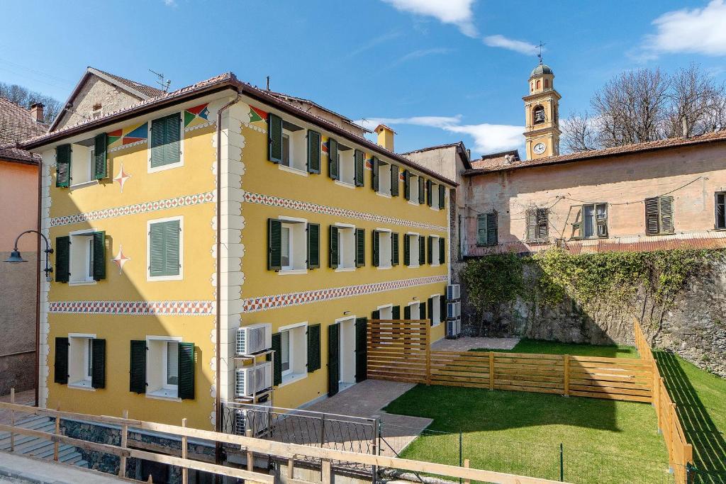 a yellow building with a clock tower in the background at Ca' Vittorio in Rossiglione