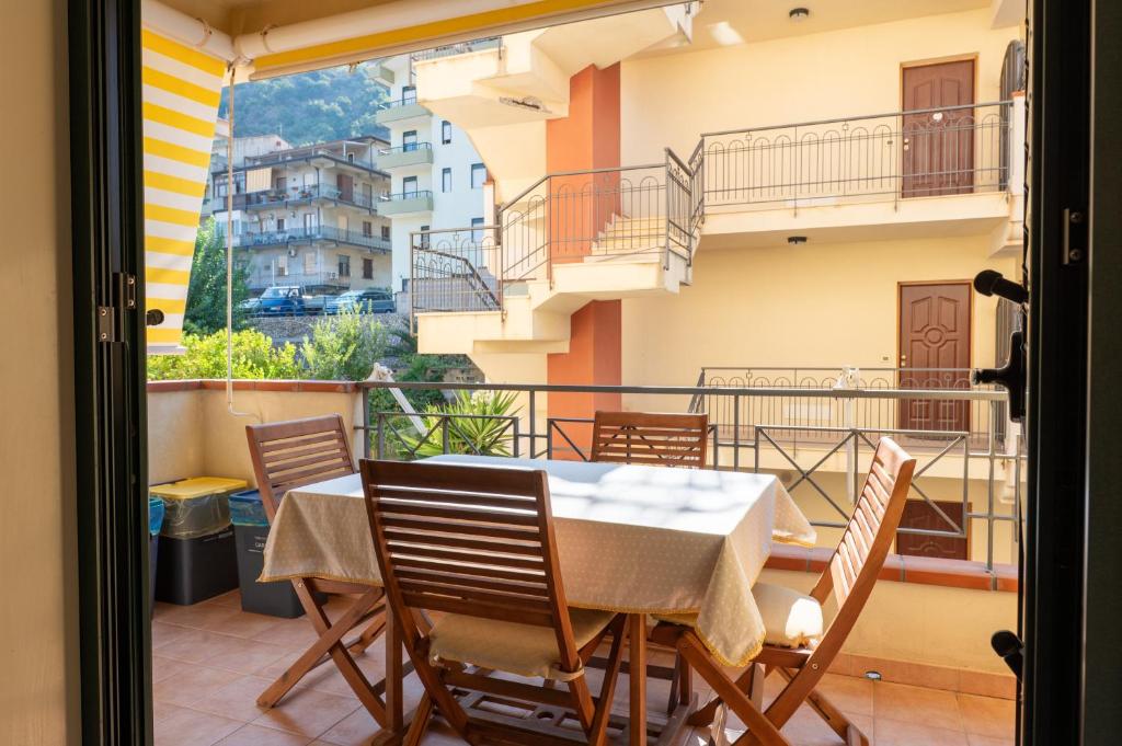 a balcony with a table and chairs on a balcony at Appartamento Vacanza Gliaca in Piraino
