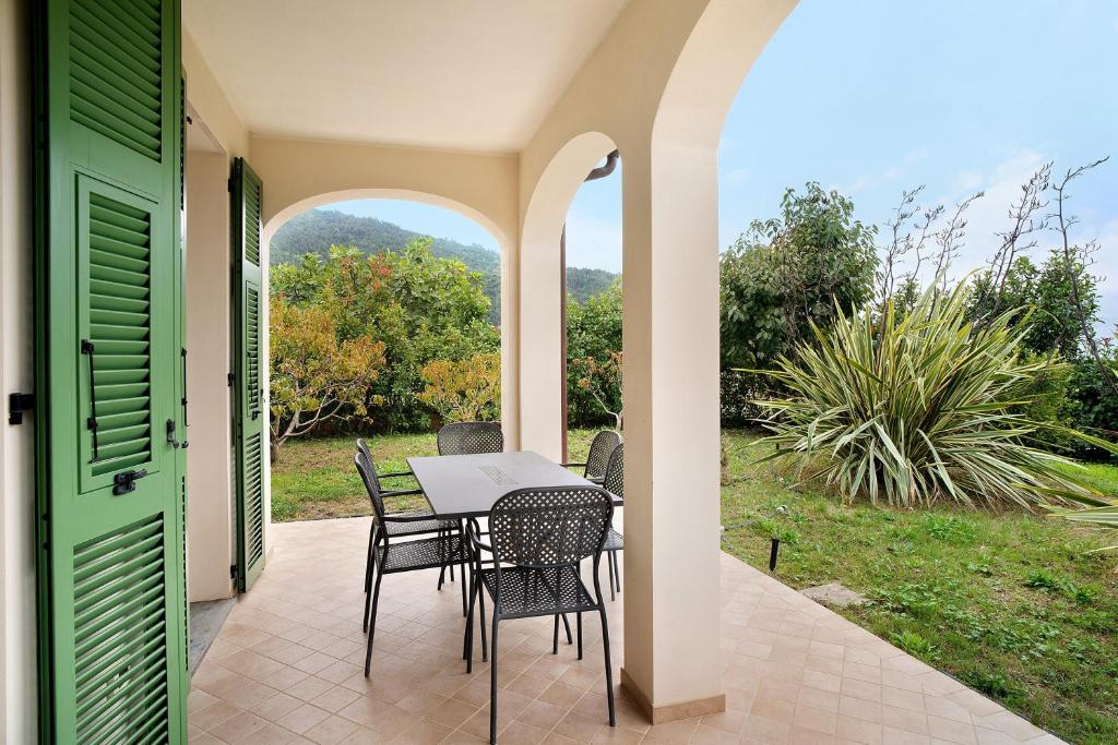 a patio with a table and chairs on a porch at Appartamento Vallebona in Seborga