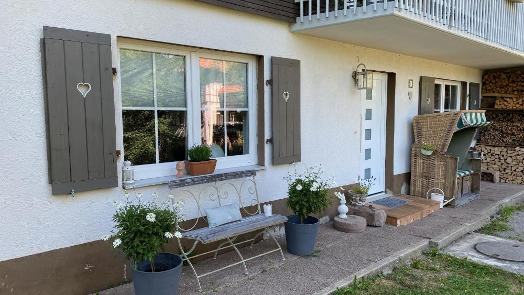 Eine Veranda mit einer Bank und Topfpflanzen in der Unterkunft Casa 2 in Todtmoos