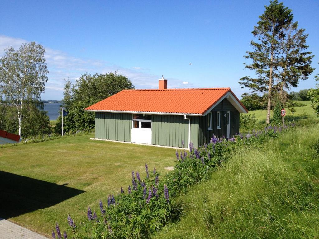 a green and white building with an orange roof at Skipper-Lodge Ost in Kosel