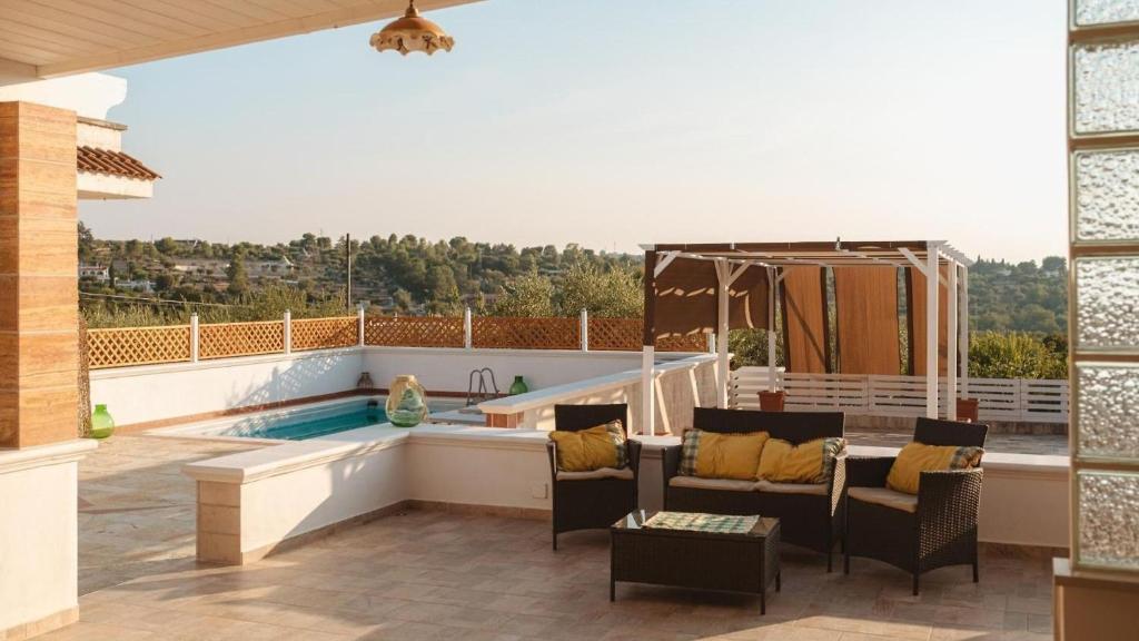 a patio with a pool and chairs and a table at Dimora Home Sweet Home with Private Pool in Putignano