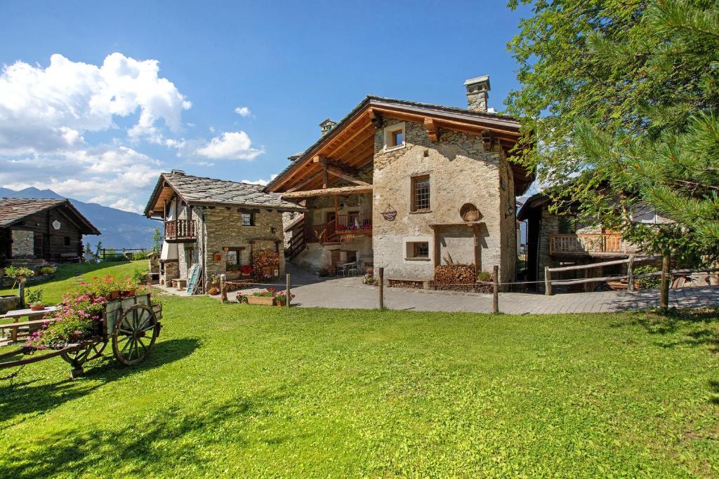a house with a wagon in front of a yard at Maison Peroulaz Charvensod in Charvensod
