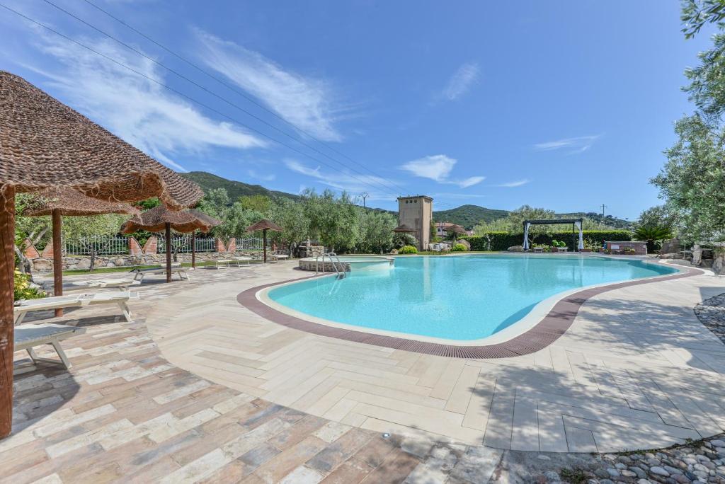 a swimming pool in a resort with a patio at Appartamenti Bonalaccia in Campo nell'Elba