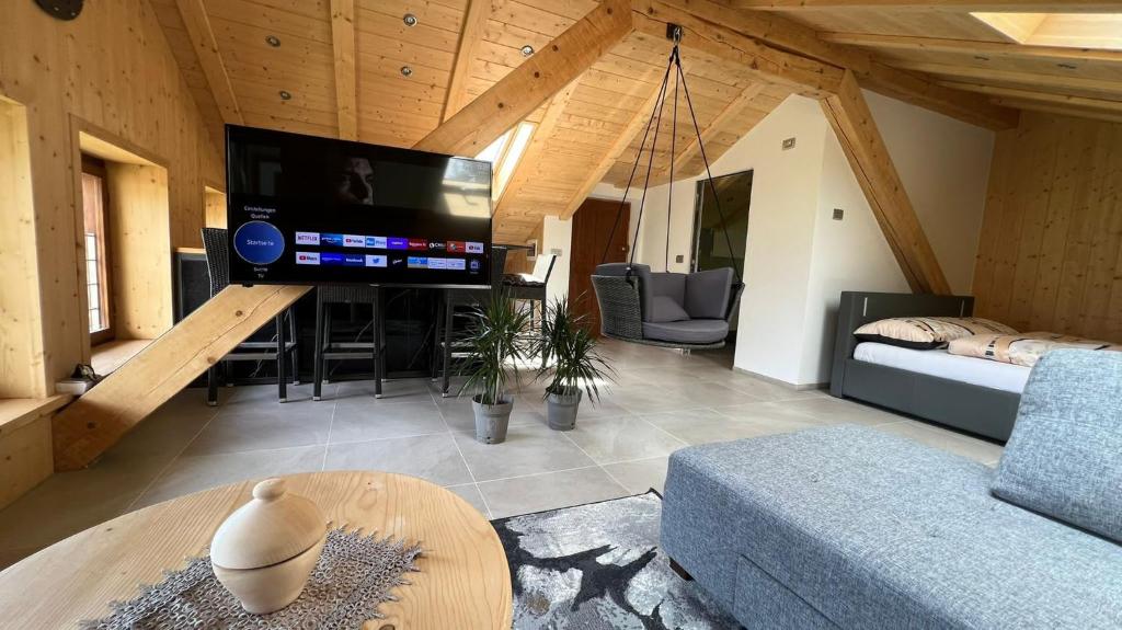 a living room with a tv and a couch and a table at Truma Swing Castelfondo in Castelfondo