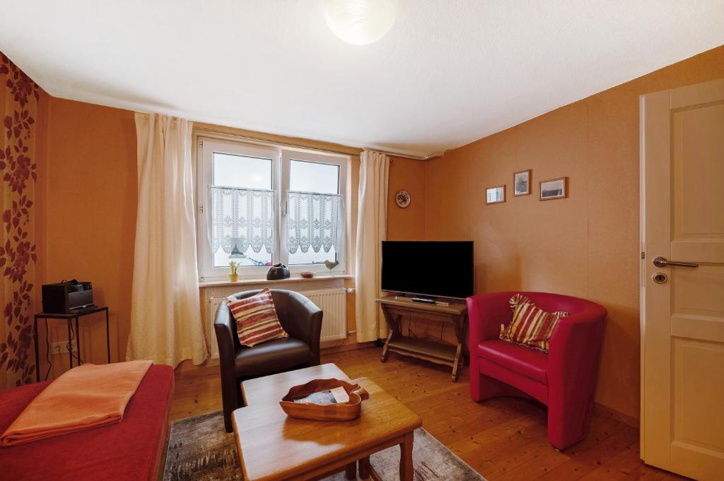 a living room with two chairs and a television at Haus Gertrud in Monzelfeld
