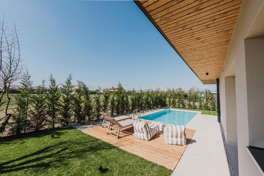 a backyard with a swimming pool and a house at Artylino in Lazise