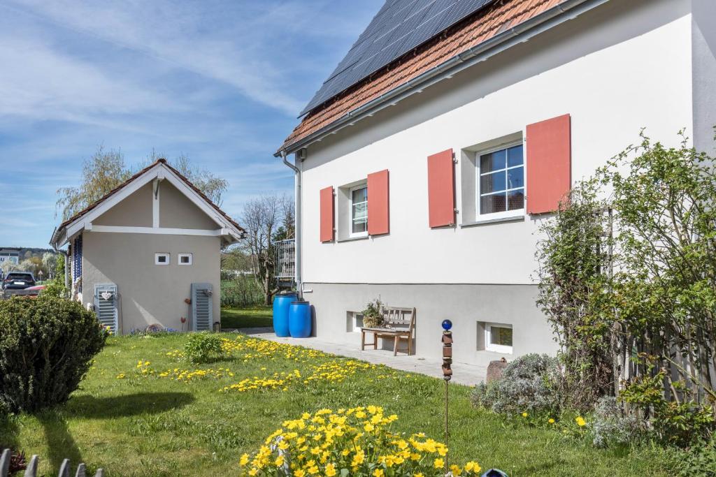 a white house with red windows and a yard at Behagliche Wohnung Hüfingen in Hüfingen