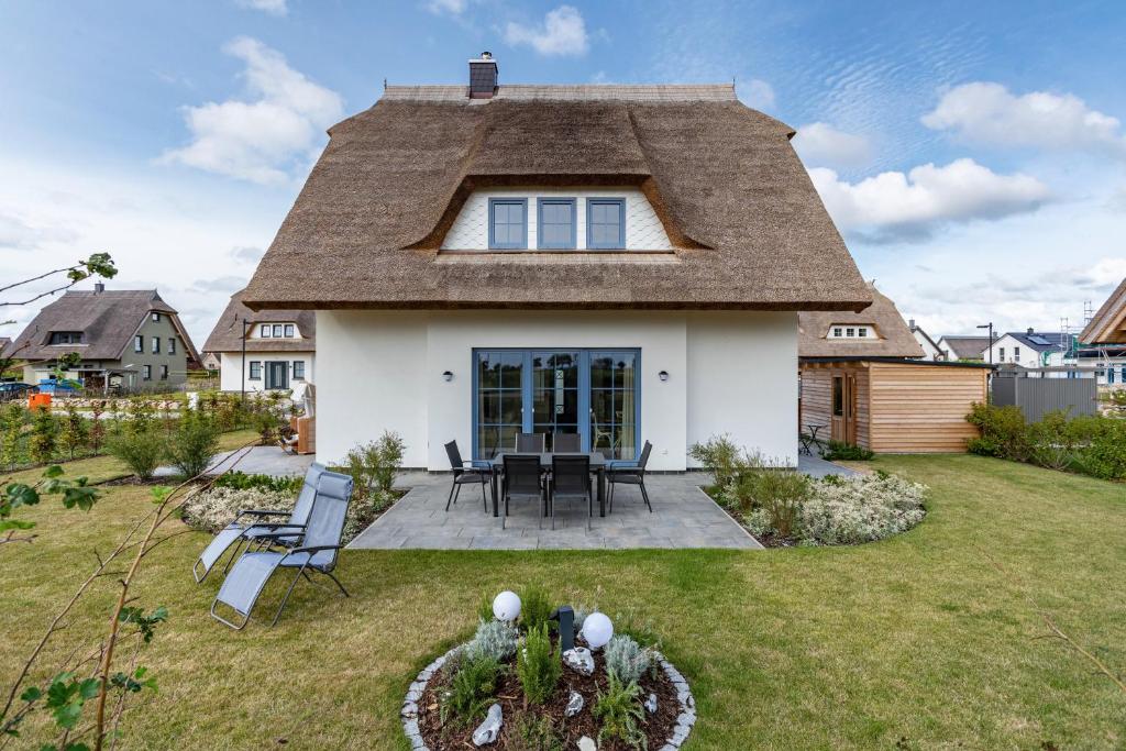 a house with a thatched roof with a patio at Maison Mer Baltique in Dranske