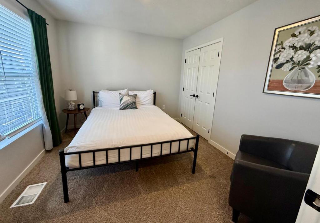 a bedroom with a bed and a chair in it at The Meadowlark at Coventry Rows in Omaha