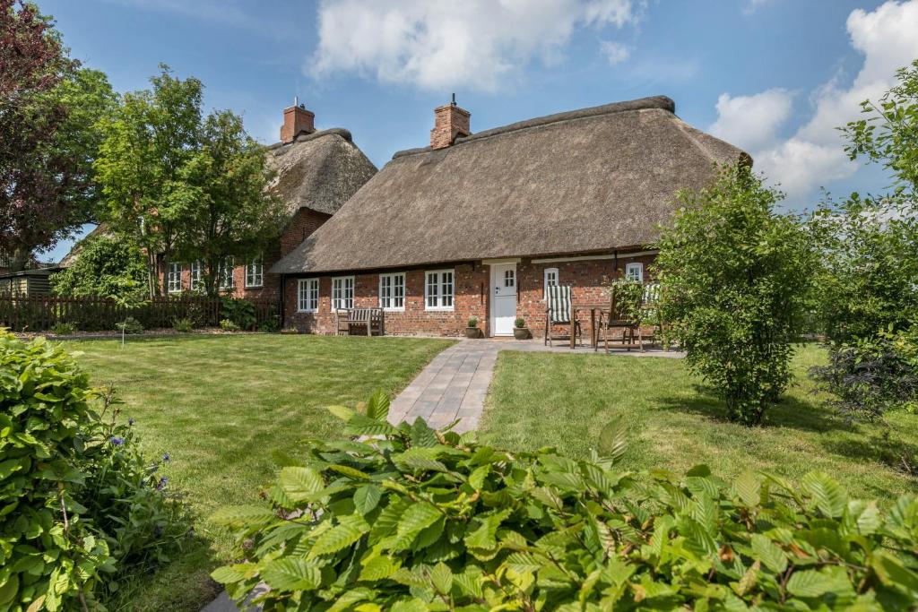 an old brick house with a thatched roof at Luis- Hus in Dagebüll