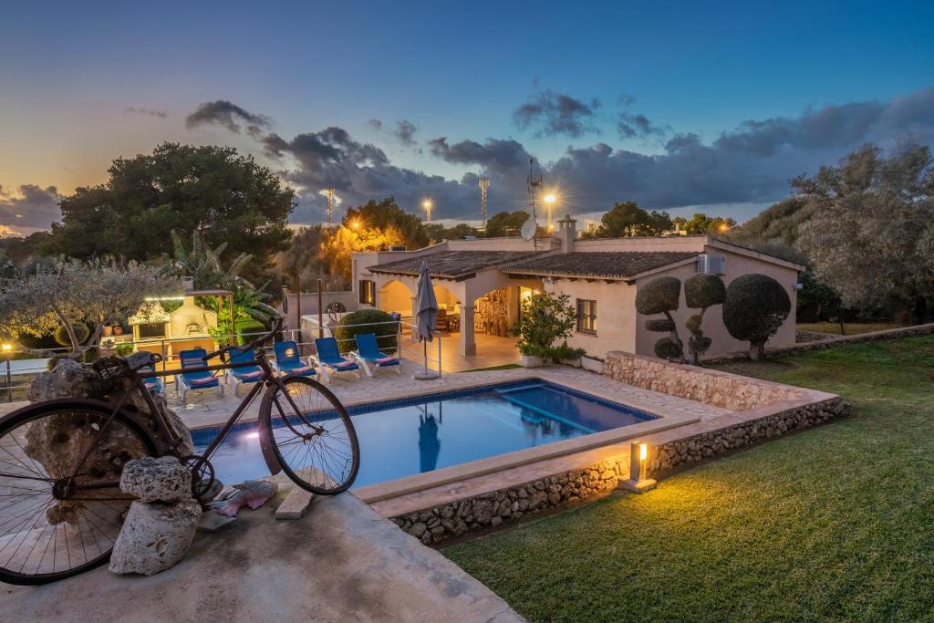a bike is parked next to a swimming pool at Sa Caseta Rustic Villa in Cala d´Or