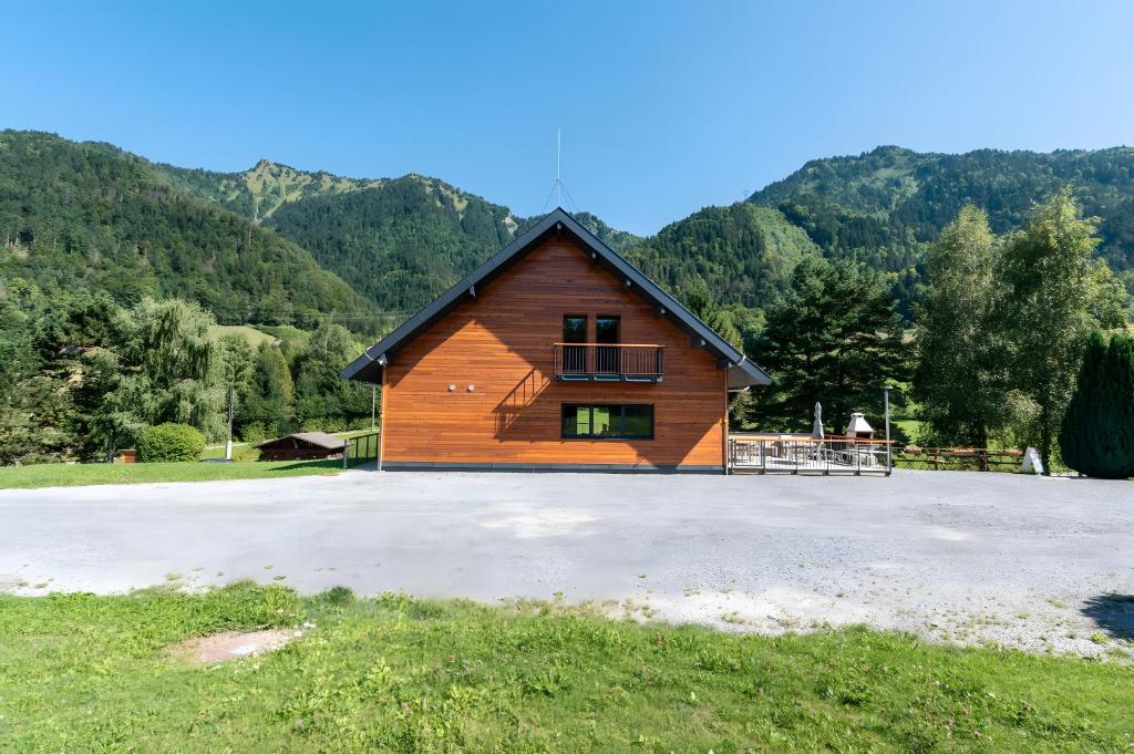 a wooden cabin in a field with mountains in the background at Hostel du Val de Tamié in Faverges