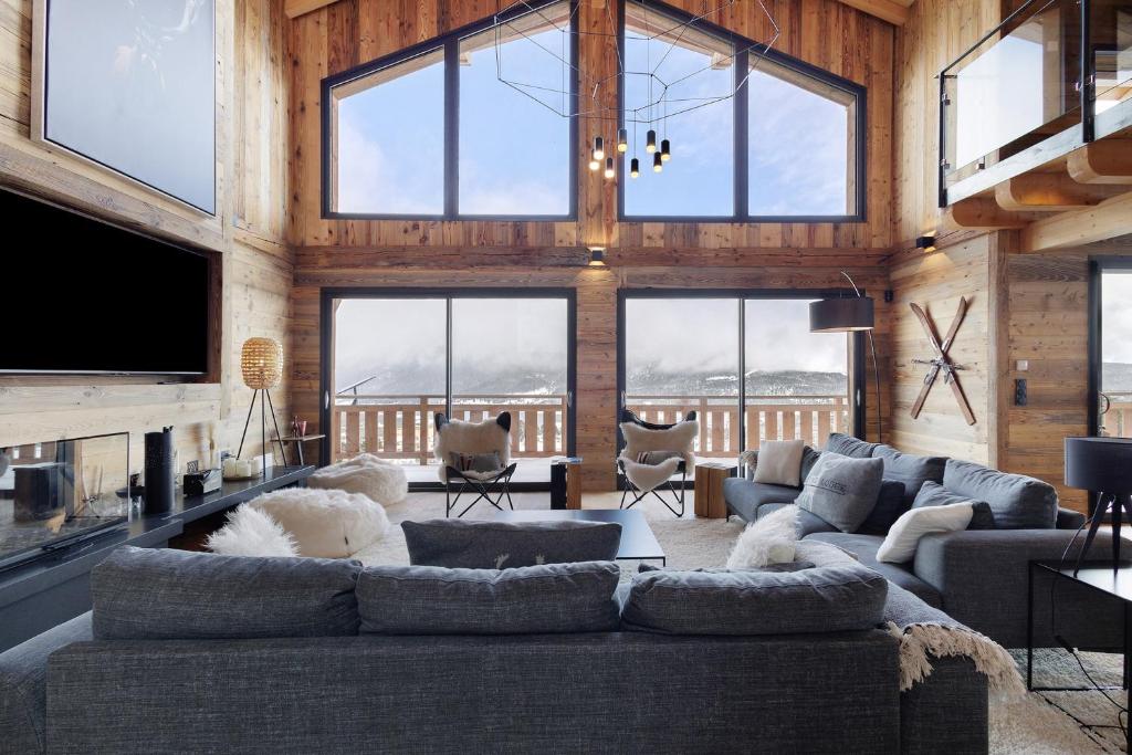 a living room with a large couch and some windows at Chalet G2 in Les Angles