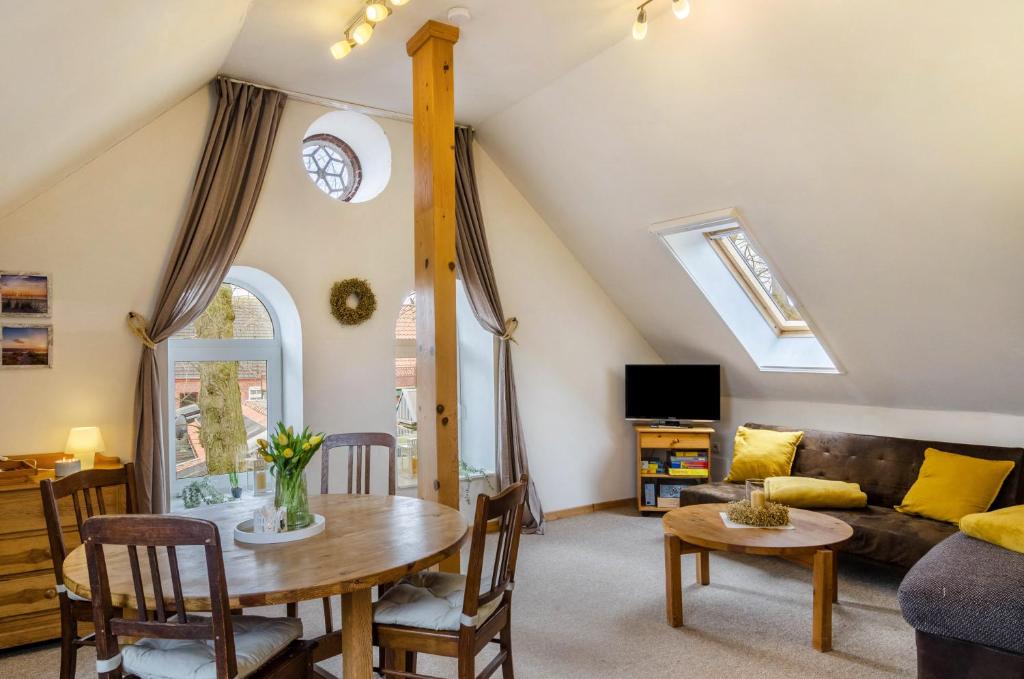 a living room with a table and a couch at Gulfhof Oldersum Dachgeschoss in Moormerland
