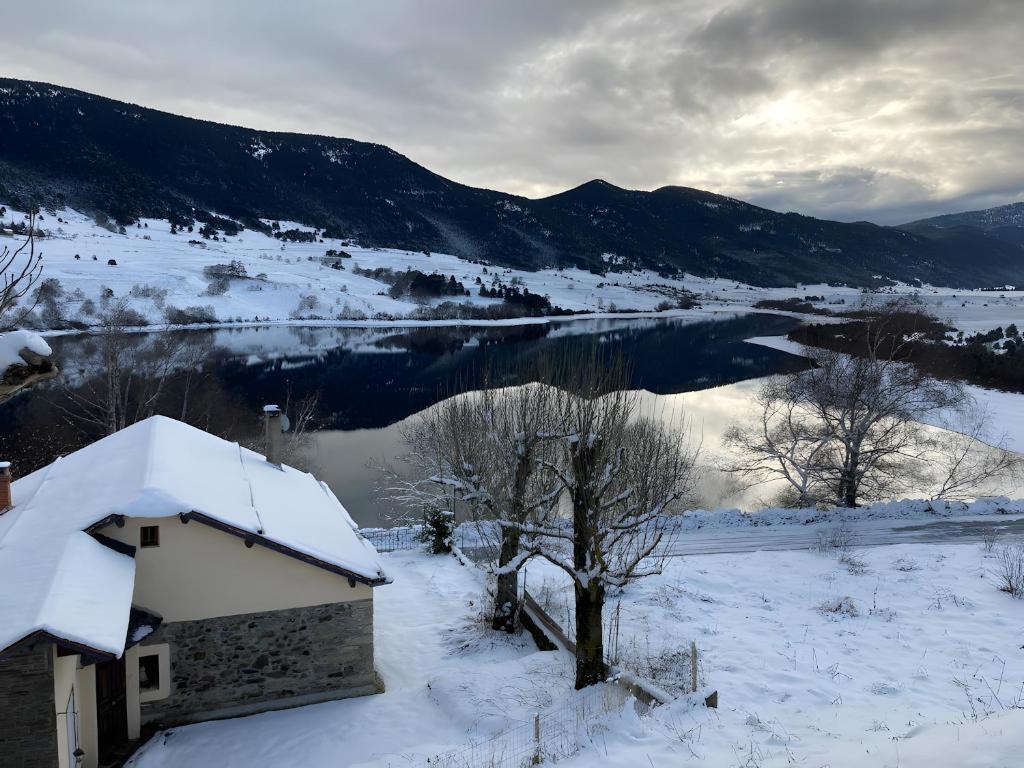 a house in the snow with a view of a lake at Logis Des Cerfs in Puyvalador