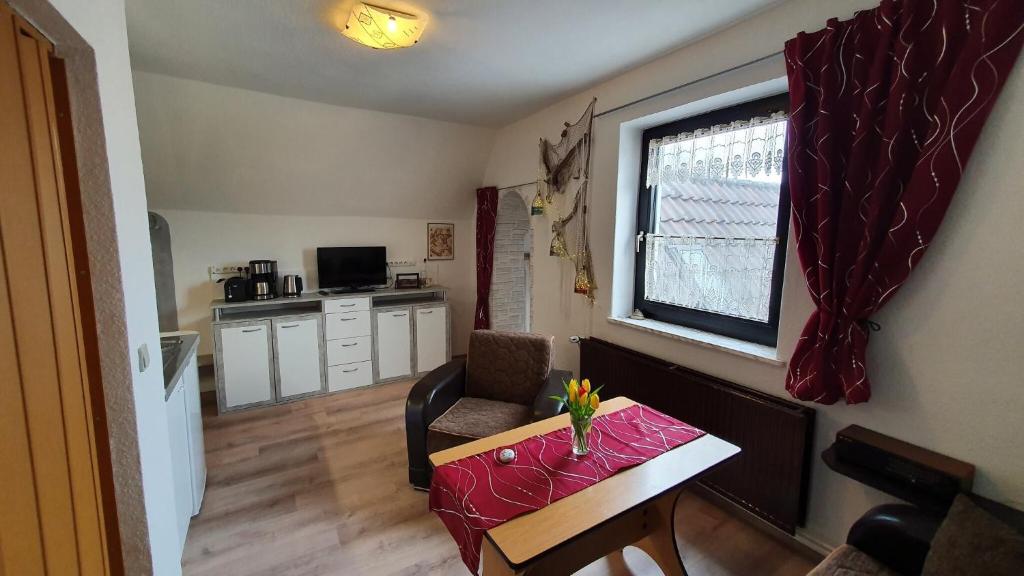 a small living room with a table and a window at Ferienwohnung Hiddenseeblick 1 in Dranske