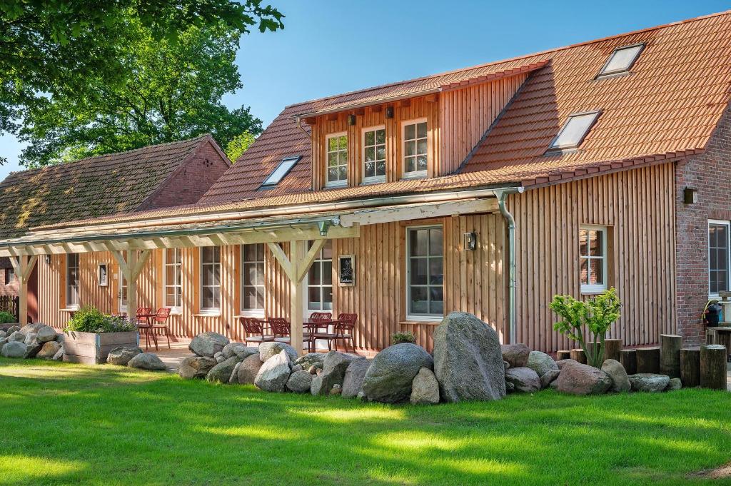 a wooden house with rocks in front of it at Eichengeflüster Kranichzimmer in Wagenfeld