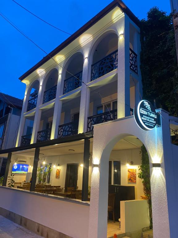 a white building with a sign in front of it at OzenTurku Hotel in Pamukkale