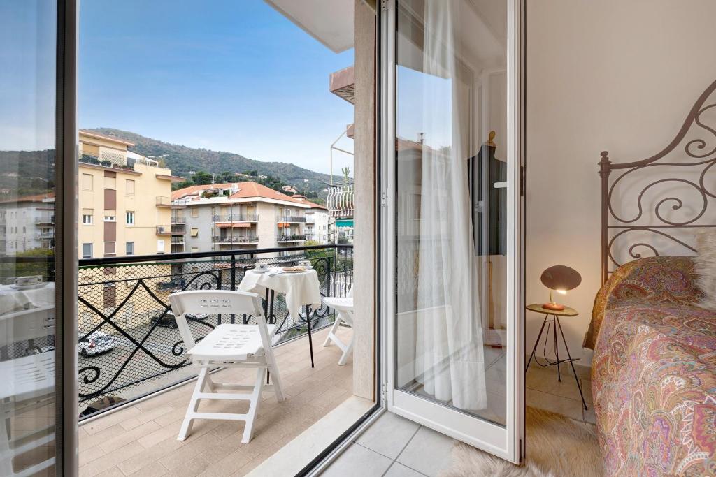a room with a balcony with a bed and a table at Casa Rosso Melograno in Alassio