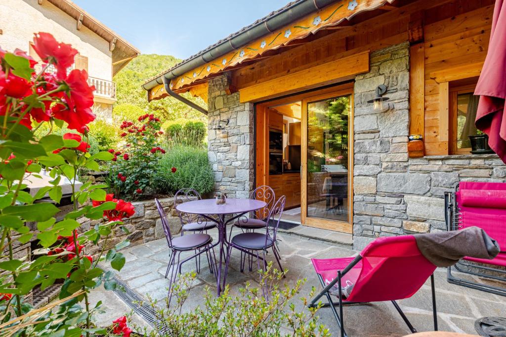 a patio with a table and chairs in front of a building at Chalet Helnes - chalet contemporain in Saint-Oyen
