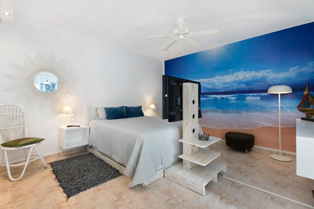 a bedroom with a bed and a painting of the ocean at Pardelo in Los Menores
