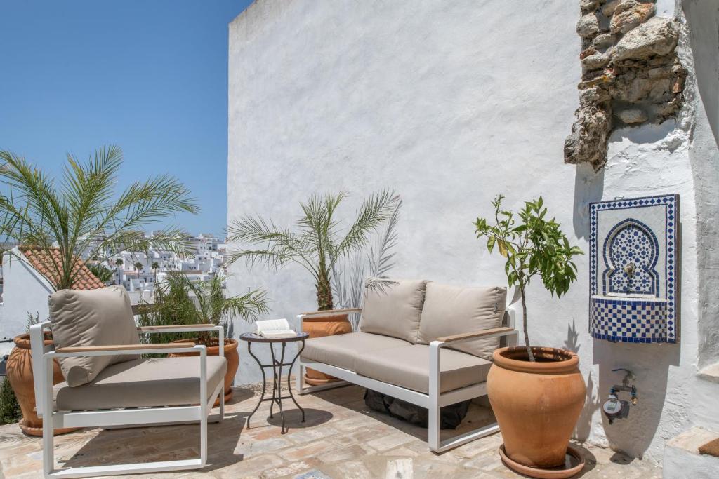 a patio with two chairs and a table at Casa Castillo con Jardín in Vejer de la Frontera