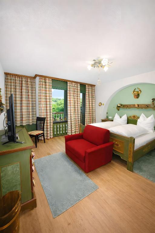 a bedroom with a bed and a red couch at Ferienwohnung Hinterthal in Hinterthal