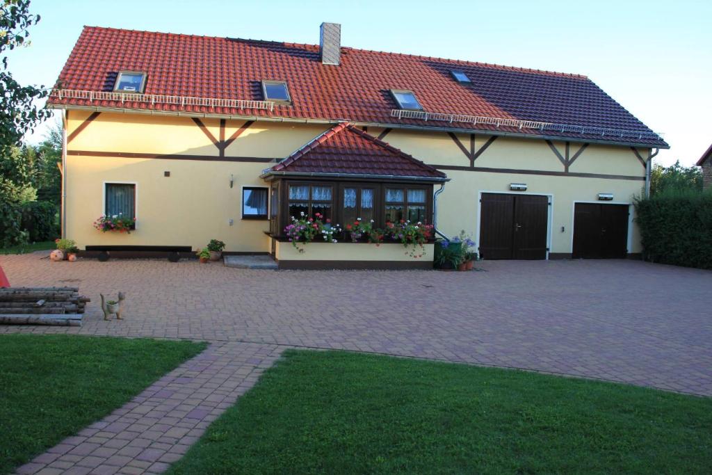 a house with a red roof and a patio at Ferienwohnung Strey in Rosenow
