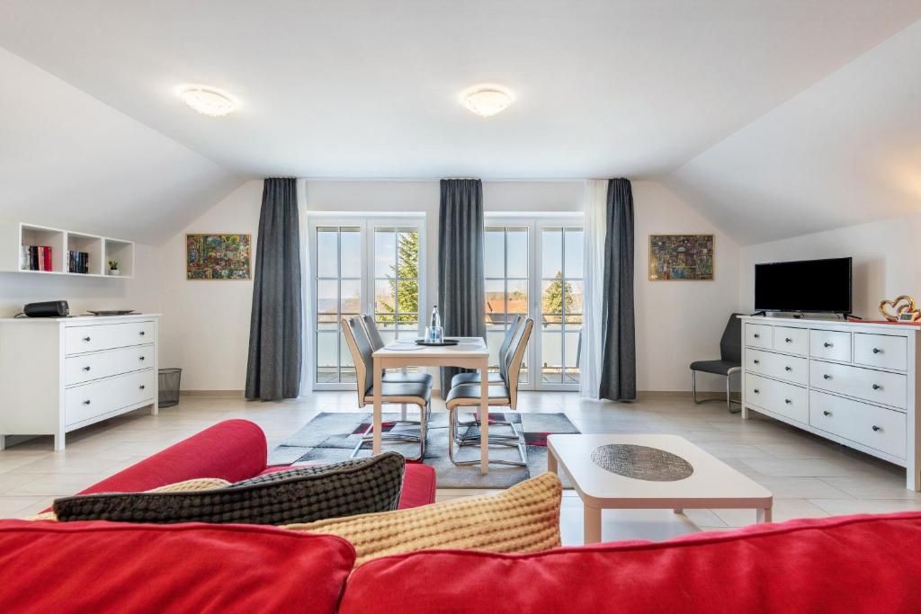 a living room with a red couch and a table at Appartement Irmi in Ihrlerstein