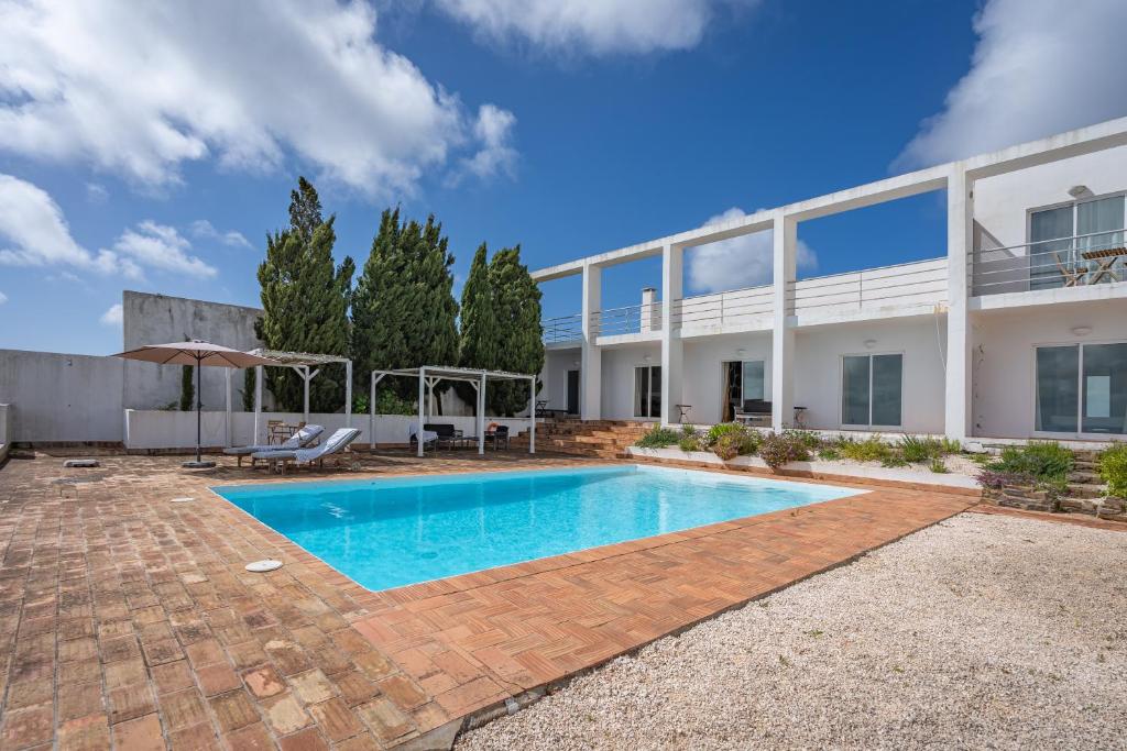 a swimming pool in front of a building at Alto da Lua - Aljezur in Bordeira