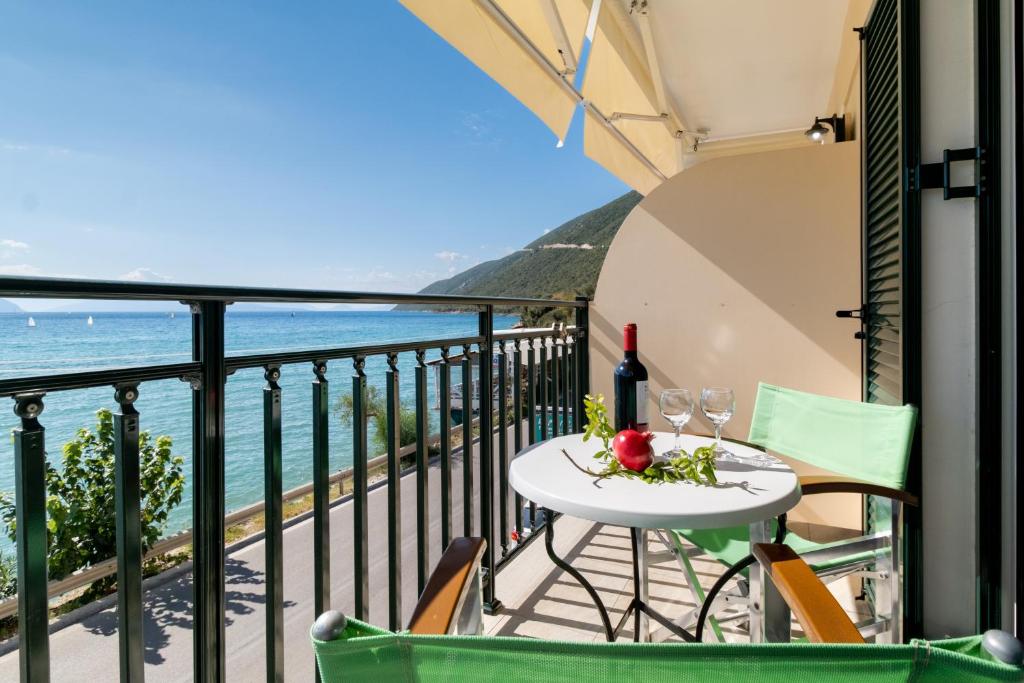 a table and chairs on a balcony with a view of the ocean at Apostolos Apartment 2 in Póndi
