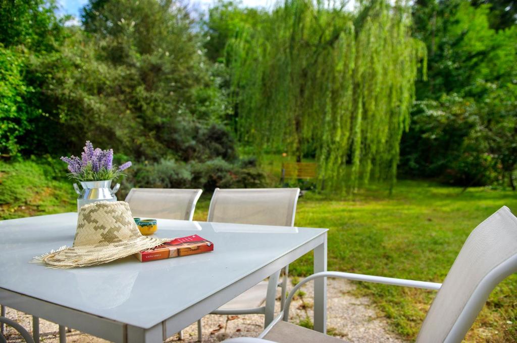 a white table with chairs and a vase with flowers on it at Il Trucchetto - Castagneto Po in Chivasso