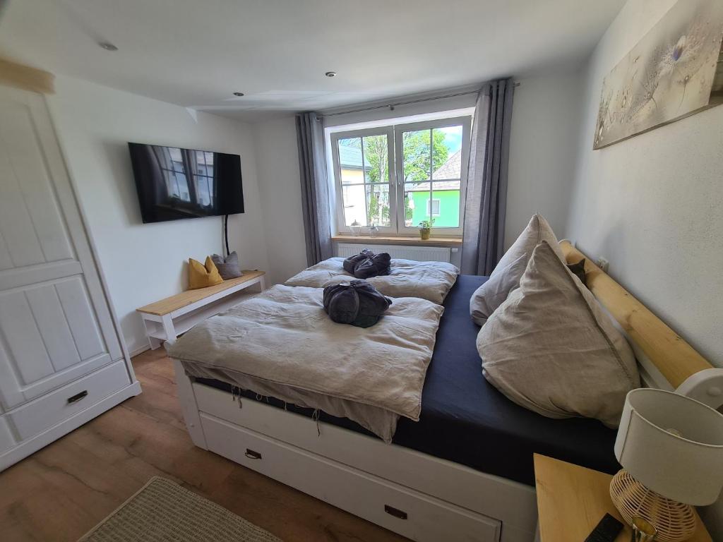 a bedroom with a bed with two bags on it at Waldstein Terrassen in Weißenstadt